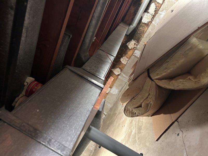 Conducted comprehensive inspection of existing ductwork system in attic and basement areas to assess condition and identify repair requirements. Documented deteriorated structural supports, compromised insulation with visible water damage and staining, and aging galvanized metal ductwork showing signs of wear. Performed detailed measurements of affected duct sections and provided photographic documentation of all areas requiring remediation, including sagging insulation, structural beam deterioration, and exposed framing components.