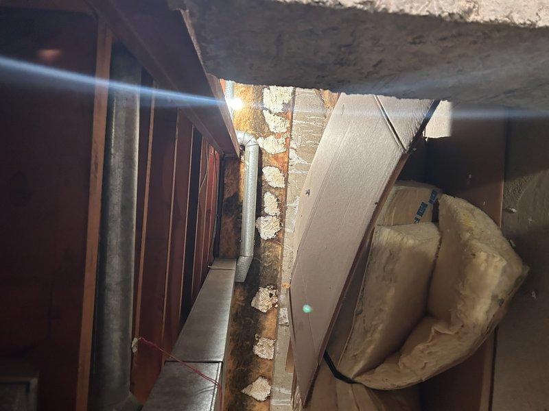 Conducted comprehensive inspection of existing ductwork system in attic and basement areas to assess condition and identify repair requirements. Documented deteriorated structural supports, compromised insulation with visible water damage and staining, and aging galvanized metal ductwork showing signs of wear. Performed detailed measurements of affected duct sections and provided photographic documentation of all areas requiring remediation, including sagging insulation, structural beam deterioration, and exposed framing components.