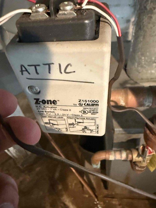 Completed on-site assessment for boiler replacement estimate at residential property. Inspected existing hydronic heating system including aged boiler equipment, pressure tank with brass fittings and red-handled isolation valve, and corroded distribution piping showing significant oxidation. Evaluated Caleffi zone actuator with end switch controlling attic zone, confirmed operational wiring connections, and documented multi-zone heating configuration. Photographed mechanical room infrastructure including exposed joists, white painted brick walls, and deteriorating pipe conditions to determine proper equipment sizing and installation requirements. Provided recommendations for new boiler system replacement based on current heating load, zone control needs, and existing piping layout.