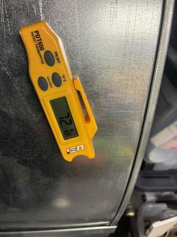 Conducted HVAC estimate for boiler system replacement. Performed temperature diagnostics using infrared thermometer on existing equipment, recording ambient temperature of 73.1°F on metallic boiler housing. Assessed outdoor condensing unit condition, noting significant age-related deterioration including dirt accumulation, surface discoloration, and environmental weathering on cabinet panels and fan assembly, indicating need for system upgrade or replacement.