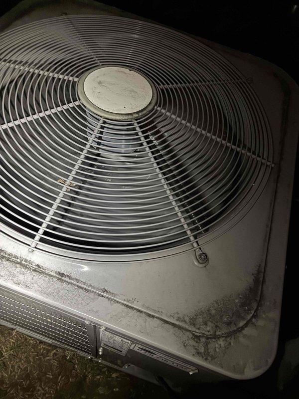 Conducted HVAC estimate for boiler system replacement. Performed temperature diagnostics using infrared thermometer on existing equipment, recording ambient temperature of 73.1°F on metallic boiler housing. Assessed outdoor condensing unit condition, noting significant age-related deterioration including dirt accumulation, surface discoloration, and environmental weathering on cabinet panels and fan assembly, indicating need for system upgrade or replacement.