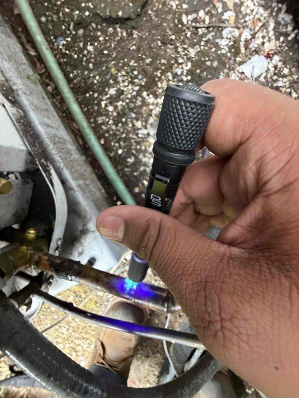 Performed UV leak detection inspection on refrigerant lines using specialized diagnostic equipment. UV tracer dye fluorescence was observed on copper refrigerant piping, confirming leak location. This is a return visit to allow dye settlement time for accurate leak identification, with follow-up scheduled to complete repairs.