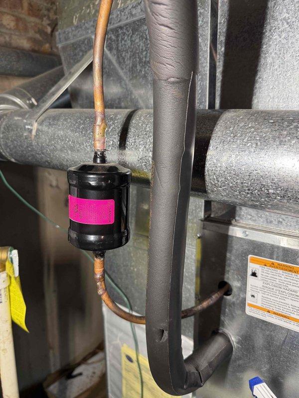 Responded to no cooling complaint on residential air conditioning system. Upon inspection, found system low on refrigerant charge. Installed filter drier on refrigerant line to remove moisture and contaminants from system. Evacuated and recharged system to manufacturer specifications. Verified proper cooling operation and system pressures before departure.
