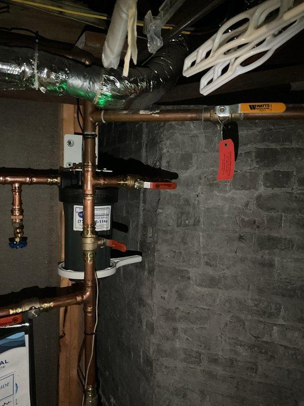 Responded to callback for non-functioning irrigation system. Upon arrival, inspected basement mechanical area and irrigation supply piping. Located backflow preventer assembly with multiple isolation valves in copper piping system mounted to concrete block wall. Verified all ball valves in proper operating position and confirmed backflow device operational. Traced supply lines through basement utility area, checking white PVC irrigation distribution pipes and associated shut-off valves. Found irrigation system isolation valve had been inadvertently closed. Opened valve to restore water supply to irrigation system. Tested system operation and confirmed proper flow restored. No deficiencies found related to previous April service visit.