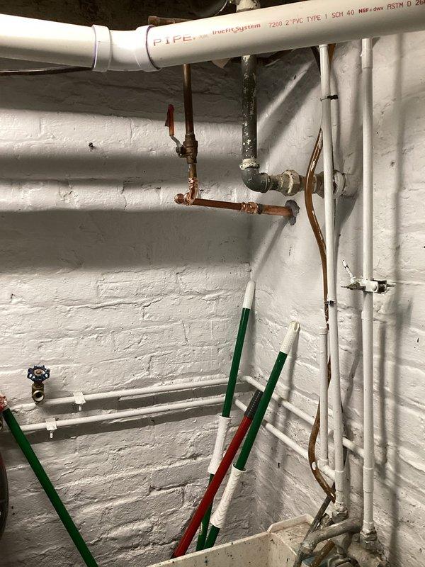 Responded to callback for non-functioning irrigation system. Upon arrival, inspected basement mechanical area and irrigation supply piping. Located backflow preventer assembly with multiple isolation valves in copper piping system mounted to concrete block wall. Verified all ball valves in proper operating position and confirmed backflow device operational. Traced supply lines through basement utility area, checking white PVC irrigation distribution pipes and associated shut-off valves. Found irrigation system isolation valve had been inadvertently closed. Opened valve to restore water supply to irrigation system. Tested system operation and confirmed proper flow restored. No deficiencies found related to previous April service visit.