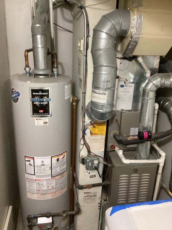 Completed HVAC maintenance agreement inspection requiring two-technician response due to access constraints. Utilized 28-foot telescopic ladder transported through residence to reach rooftop condensing unit. Performed comprehensive system evaluation including blower motor assembly inspection, verified proper operation of fan blade rotation and motor shaft integrity. Documented equipment condition with photographic evidence showing gray cylindrical housing with center-mounted flange assembly and radial blade configuration. Inspected residential mechanical room containing gas furnace with horizontal louver panel, metallic ductwork with reflective insulation, and water heater with Defender Safety System. Verified proper electrical connections, condensate drainage via white PVC piping, and overall system functionality. All components operating within normal parameters at time of inspection.