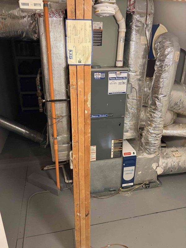 Conducted comprehensive HVAC estimate for complete air conditioning system replacement on residential property with existing 20+ year old unit that has reached end of service life. Evaluated current American Standard furnace and air handler installation in basement mechanical room, documented existing ductwork configuration including flexible insulated ducts and reflective insulation, assessed copper refrigerant line routing and PVC condensate drainage system, photographed equipment dimensions and clearances for proper replacement unit sizing, and verified gas line connections and venting arrangements to ensure compatibility with new system specifications.