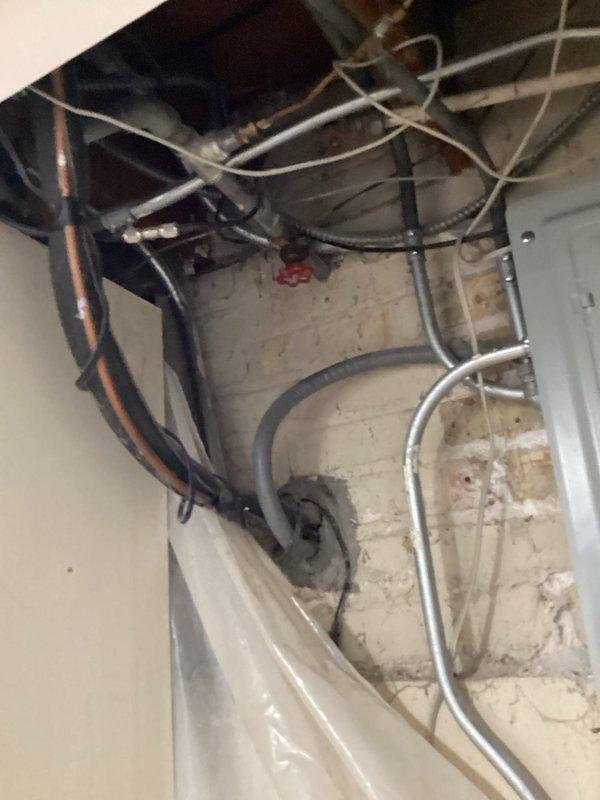Conducted comprehensive site assessment of residential plumbing system with original galvanized piping requiring conversion to copper. Inspected dual water heater installation in utility area, evaluating existing gas valve assemblies, ventilation configurations, and connection points. Assessed routing pathways through walls and ceiling cavities where existing black iron and galvanized supply lines will require replacement. Documented congested mechanical chase areas containing multiple utility runs that will need coordination during repipe execution. Photographed water heater setup including control mechanisms, brass fittings, and venting arrangements to ensure proper integration with new copper distribution system. Evaluated water filtration system requirements and optimal placement locations. Prepared estimate for complete galvanized-to-copper repipe project including water treatment system installation.