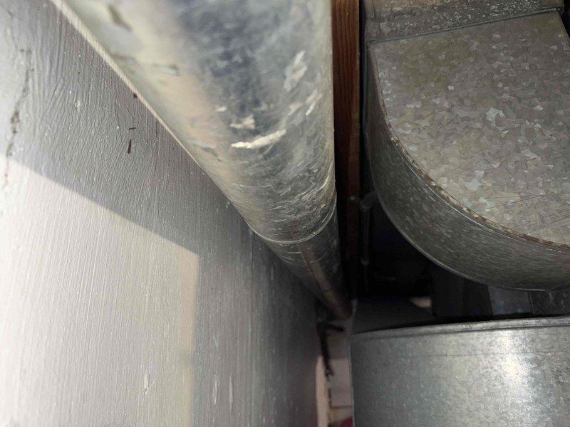 Responded to emergency service call for a one-year-old gas water heater experiencing improper venting issues. Upon arrival, inspected the Rheem brand water heater installation in the basement utility room and assessed the complete venting system running through the ceiling joists and attic space. Examined the existing vent pipe configuration, including the flexible ductwork, rigid metal ductwork components, and all connection points from the appliance draft hood through the termination point. Identified venting deficiencies preventing proper exhaust of combustion gases. Corrected the venting system to ensure proper draft and compliance with manufacturer specifications and local code requirements. Verified all duct connections were properly sealed and secured. Tested the water heater operation, confirmed proper venting function, and verified adequate combustion air supply. System restored to safe operating condition with proper exhaust ventilation established.