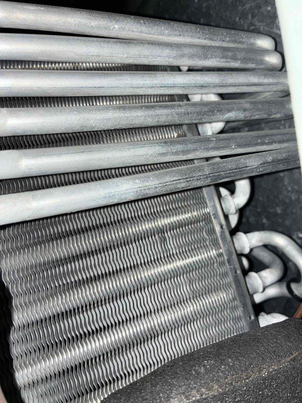 # Service Summary

Responded to no-cool complaint on 10-year-old residential air conditioning system. Upon arrival, found outdoor condenser unit heavily obstructed by overgrown vegetation and coil significantly contaminated with dirt and debris accumulation. Blower motor confirmed non-operational during initial inspection.

# Work Performed

Cleared vegetation from around condenser unit to restore proper airflow and accessibility. Conducted thorough visual inspection of evaporator coil, noting substantial dust and dirt buildup on aluminum fins and plates affecting heat transfer efficiency. Assessed blower motor assembly and determined motor failure as primary cause of no-cool condition.

Replaced failed blower motor with appropriate replacement unit. Cleaned evaporator coil fins to remove accumulated debris and restore airflow capacity. Inspected refrigerant lines and insulation for damage—found lines intact with insulation in serviceable condition. Verified all electrical connections 