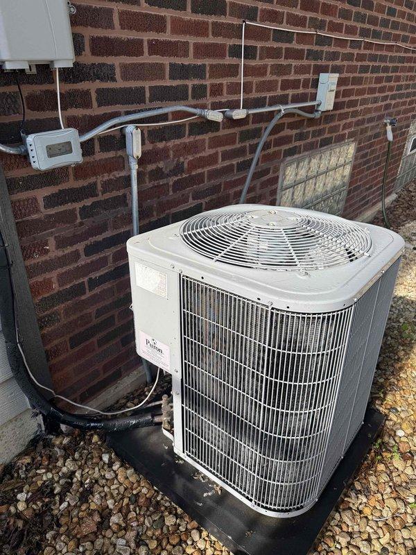 Completed comprehensive cooling system maintenance agreement inspection on residential split system. Performed thorough evaluation of outdoor condensing unit positioned on proper drainage pad with adequate clearance, verified electrical connections and disconnect functionality, and inspected indoor air handler unit located in attic space. Documented system condition with photographic records showing proper installation, confirmed all safety labels present, and noted equipment operating within normal parameters.