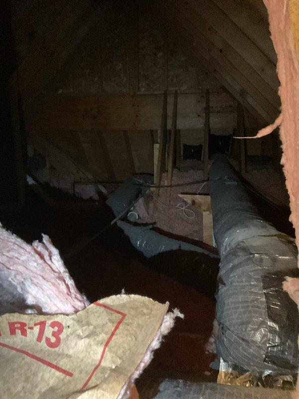 Responded to no cooling complaint and discovered leaking air duct penetrating ceiling with conditioned air escaping into wall cavity and attic space. Documented damaged flexible ductwork with compromised insulation wrap and noted access limitations requiring smaller technician for proper repair in confined attic area.