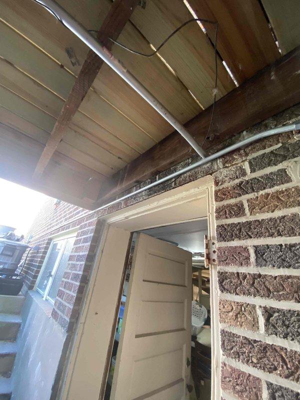 Completed full replacement of mini split system over three-day period with two-technician crew. Installation included routing of refrigerant lines and electrical conduit through covered exterior porch area along wooden beam structure and brick wall exterior, with interior penetration for wall-mounted air handler unit. All line sets, condensate drainage, and electrical connections properly installed and secured per manufacturer specifications, with system tested and confirmed operational upon completion.