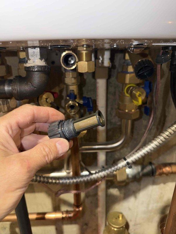 Performed preventive maintenance on boiler system under service agreement. Removed and inspected inlet water filter screen, which showed debris accumulation. Cleaned filter component by soaking in solution to remove sediment and mineral deposits. Reinstalled filter with proper threading and verified secure connection. Inspected all associated plumbing connections, brass fittings, shut-off valves, and flexible supply lines for signs of wear or leakage. Confirmed system integrity and proper operation upon completion.