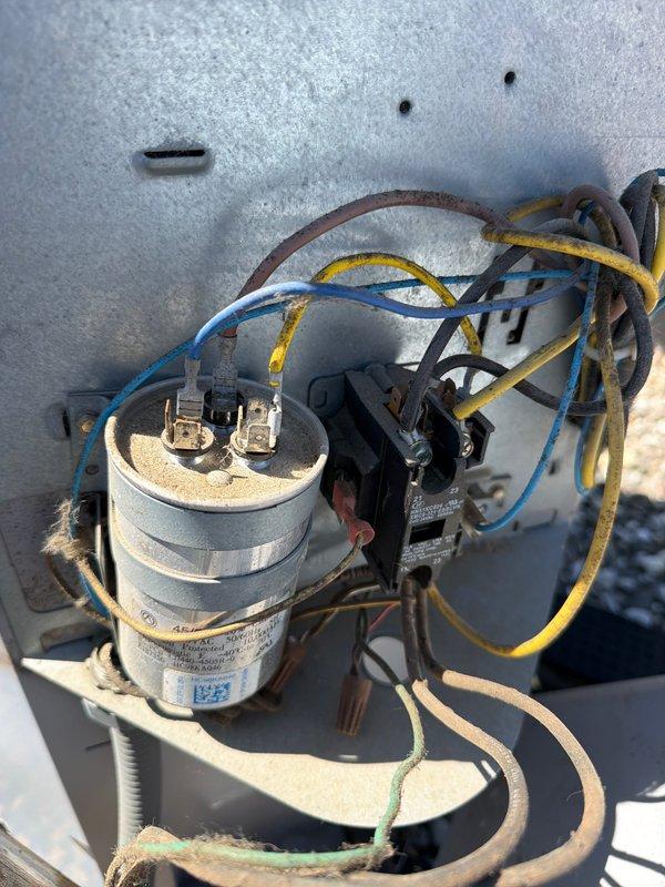 Responded to no cooling complaint on residential HVAC system. Upon arrival, customer was out of town and unit had been non-operational for multiple days per thermostat app notification. Inspected outdoor condensing unit and found failed dual run capacitor with visible aging, discoloration, and compromised wire connections. Replaced defective capacitor and verified proper electrical connections to compressor and condenser fan motor. Additionally inspected indoor air handler and found heavily soiled air filter restricting airflow, which contributed to system inefficiency and potential premature component failure. Replaced dirty filter with new pleated media filter to restore proper airflow. Cycled system through complete cooling operation and confirmed compressor startup, condenser fan operation, and adequate airflow at registers. System now cooling properly and operating within normal parameters.