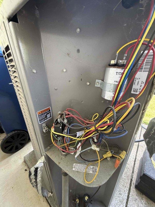 Completed comprehensive preventative maintenance inspection on air conditioning system per agreement specifications. Inspected condenser coil for cleanliness and leaks, verified blower motor and wheel condition, tested indoor relative humidity levels, and measured refrigerant charge. Cycled and inspected all operating controls for proper function. Examined line voltage switches, wiring connections, and electrical components for tight connections and signs of deterioration. Verified condensate drainage system operating correctly and inspected refrigerant lines for visible leaks and insulation integrity. Photographically documented condenser fan assembly with protective wire guard and motor housing, as well as electrical compartment showing capacitor, contactor, and wiring connections. All components found operational with normal wear patterns consistent with regular use. System operating within manufacturer specifications.