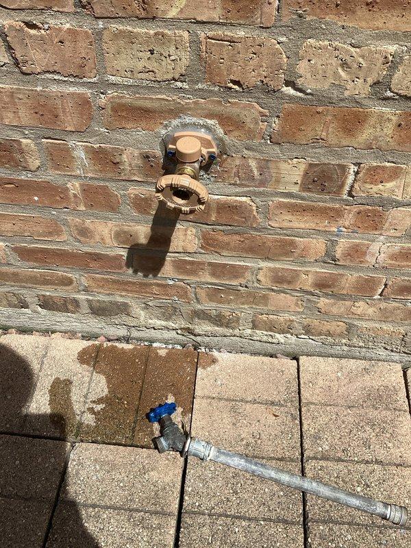 Responded to service call for leaking outside faucet. Upon inspection, identified failed washer and worn internal components causing water seepage from the hose bib spout. Shut off water supply, disassembled the outdoor faucet assembly, and replaced deteriorated rubber washer and stem packing. Reassembled unit, restored water supply, and tested for proper operation and leak-free performance. Verified no additional leaks at wall penetration point and confirmed solid connection to copper supply line.