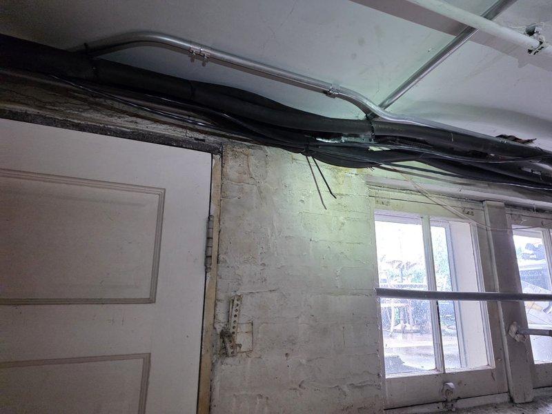 Completed mini-split system replacement in residential space undergoing renovation. Removed existing unit and installed new mini-split system with proper refrigerant line routing through exposed ceiling joists and structural areas. Secured all copper linesets, condensate drainage, and electrical conduit per manufacturer specifications. Coordinated installation around active construction elements including exposed framing, existing plumbing infrastructure, and utility lines. Ensured proper clearances for all mechanical components and verified system operation upon completion.