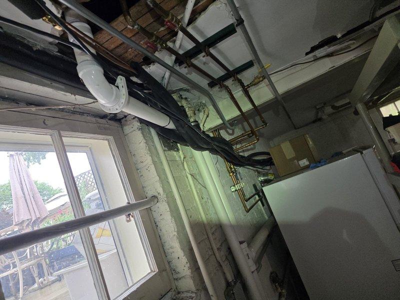 Completed mini-split system replacement in residential space undergoing renovation. Removed existing unit and installed new mini-split system with proper refrigerant line routing through exposed ceiling joists and structural areas. Secured all copper linesets, condensate drainage, and electrical conduit per manufacturer specifications. Coordinated installation around active construction elements including exposed framing, existing plumbing infrastructure, and utility lines. Ensured proper clearances for all mechanical components and verified system operation upon completion.