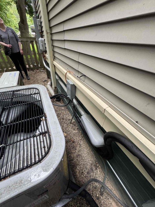Completed installation of single-zone ductless mini-split air conditioning system at residential property. Mounted outdoor condensing unit on concrete pad at exterior foundation with proper clearances, ran insulated refrigerant line sets along base of structure, and installed indoor wall-mounted air handler unit in upper room with vaulted ceiling. System was properly commissioned, tested for proper operation, and left in full working condition.
