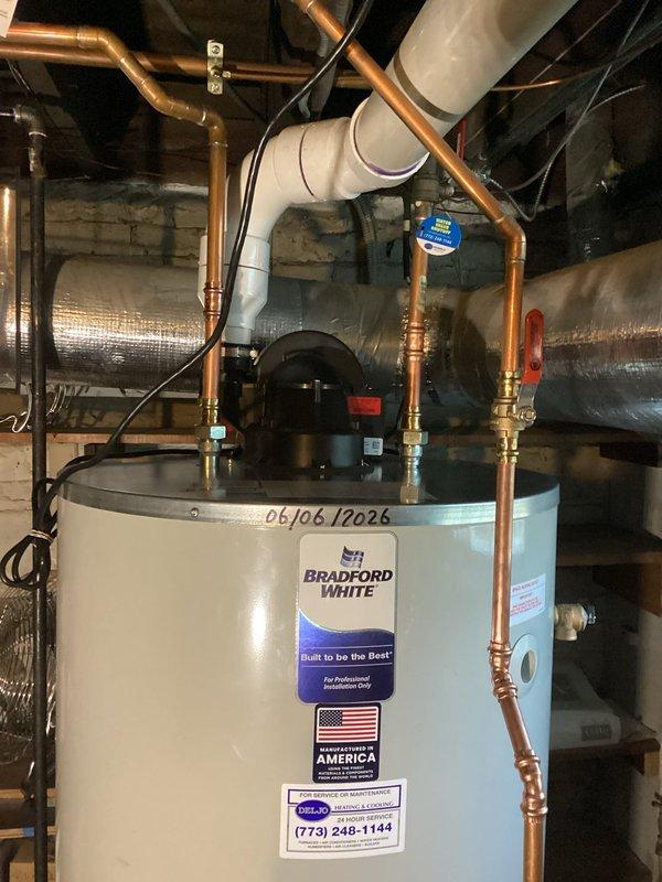 Installed a new 75-gallon Bradford White residential water heater in basement utility area. Performed complete water heater replacement including all necessary copper supply line connections with brass fittings and valves, installed recirculation pump with electrical connections, and connected required PVC venting. Unit was properly positioned on concrete floor, all plumbing connections were secured and tested for leaks, and system was commissioned and verified operational.