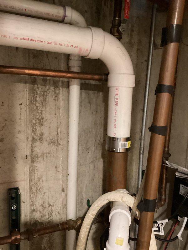 Replaced failed copper drain piping with PVC drainage system in basement utility area. Installation included proper fitting connections, secure mounting to concrete block wall, and integration with existing plumbing infrastructure. Work completed in compliance with applicable plumbing codes.