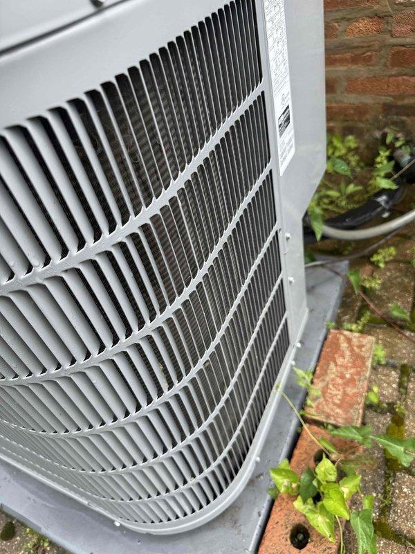 Completed routine HVAC maintenance agreement service on split system including outdoor condensing unit and indoor air handler/furnace. Performed comprehensive system inspection, verified proper operation of all components, and documented equipment condition with photos showing outdoor unit positioned against brick wall with moss growth on surrounding surfaces and indoor equipment installation in utility closet with connected ductwork and piping.