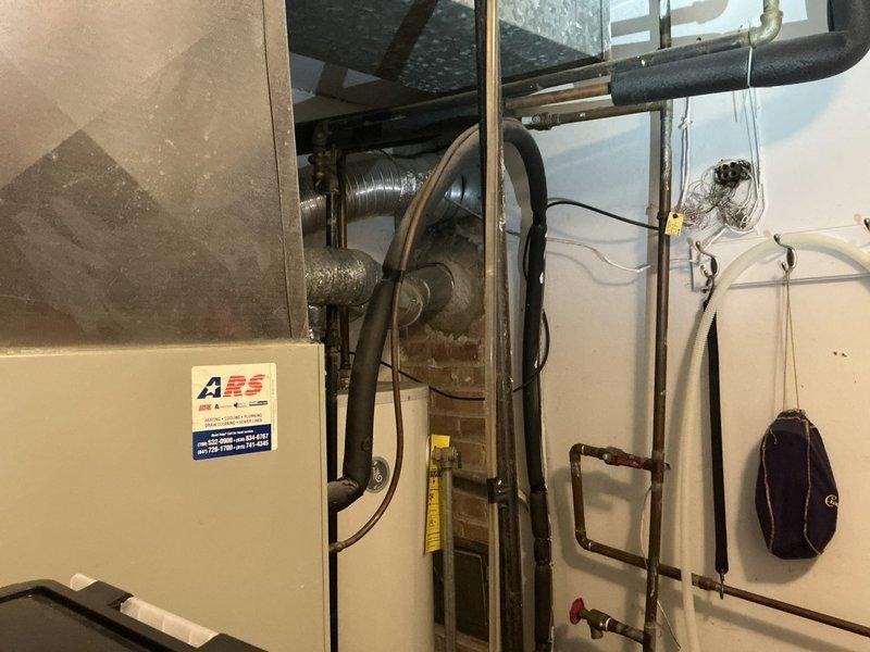 Conducted comprehensive evaluation of existing 20+ year old HVAC system located in attic utility space with confirmed refrigerant leak previously diagnosed by another contractor. Assessed cramped installation area with sloped ceiling and limited access for equipment removal and replacement considerations. Inspected current heating and cooling unit, blower assembly, copper refrigerant lines with service valves, and associated ductwork connections. Documented existing system configuration including electrical wiring, condensate drainage, and mechanical room plumbing components. Provided detailed estimate for complete HVAC system replacement including new air handler, condensing unit, refrigerant line set, electrical connections, thermostat, and all necessary accessories to restore reliable climate control operation.