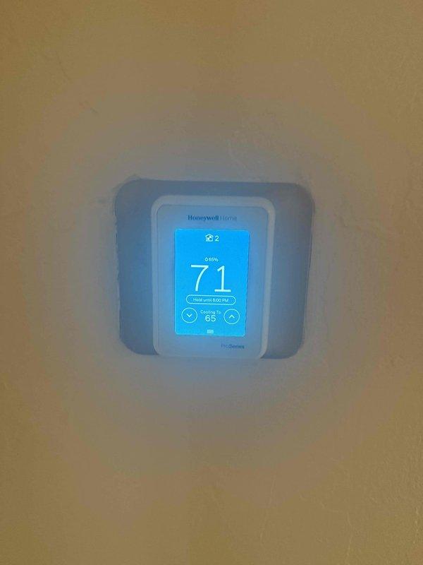 Completed comprehensive cooling maintenance on two air conditioning systems per maintenance agreement. Verified thermostat operation showing 71°F current temperature with proper heat setpoint at 65°F, inspected blower assembly revealing normal dust accumulation on squirrel cage fan blades and housing consistent with operational use, and documented system conditions through photographs for service records.