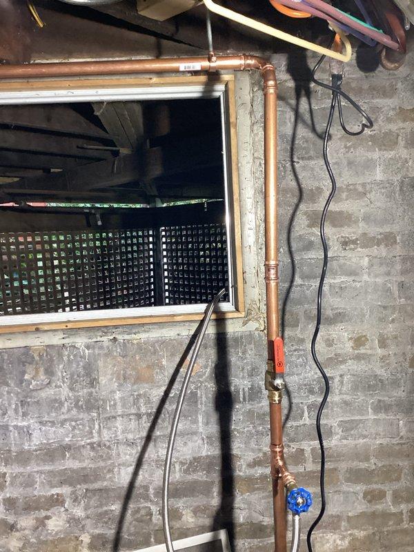 Completed installation of RPZ backflow preventer and booster pump system for residential irrigation. Mounted pump assembly on concrete pad in basement utility area with proper electrical connection and integrated pressure tank. Installed copper piping with soldered joints, pressure gauge, braided stainless steel flex connector, and shutoff valves to ensure code-compliant operation and system protection.