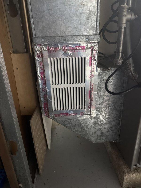 Returned to property to install new supply grills in attic space as previously scheduled. Installed white rectangular return air grille with vertical slats on galvanized ductwork, secured with professional-grade tape to ensure proper seal. Per customer request, inspected outdoor condenser unit and evaluated existing concrete pad condition. Found significant debris accumulation around condenser including leaves, organic matter, and vegetation growth on pad surface. Documented extensive weathering, dark staining, and deterioration of concrete slab with photographic evidence. Pad appears undersized for current equipment and shows signs of prolonged moisture exposure with moss and weed growth throughout area. Provided customer with photos showing current conditions for review regarding potential pad upgrade and replacement options.