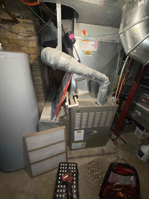 Completed preventive maintenance inspection on HVAC system including three condensing units. Performed comprehensive evaluation of basement-located Carrier furnace unit, inspecting blower assembly and verifying proper operation of squirrel cage fan. Examined air handling components, ductwork connections, and system airflow. Documented equipment condition through photographic records showing blower wheel assembly with normal operational dust accumulation and overall system status. All units inspected and found operational per maintenance agreement specifications.
