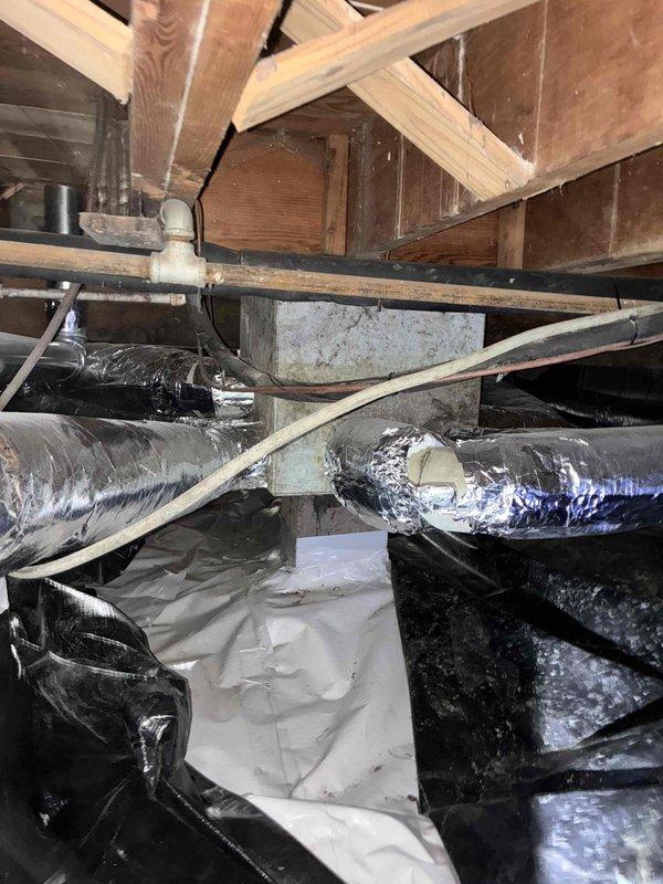 Responded to warranty callback regarding refrigerant line installation in crawl space. Entered wet crawl space and performed thorough inspection of refrigerant lineset routing and support. Found lineset hanging lower than optimal clearance from concrete floor surface, which showed evidence of moisture and biological growth. Secured and re-supported refrigerant lines using additional metal strapping to wooden floor joists above, achieving proper clearance from ground surface. Verified all insulation remained intact on lineset throughout crawl space. Documented conditions with photos and reviewed completed work with customer on site, confirming concerns were addressed to satisfaction.