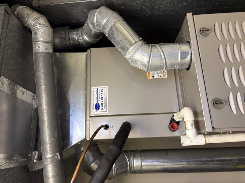 Completed HVAC system replacement for a nearly 10-year-old unit with a loud condenser. The existing system was easily accessible in the utility space, facilitating efficient removal and installation. Replaced the complete air handler unit with new equipment, including proper connection of all metallic flexible ductwork, refrigerant lines with black foam insulation, and electrical components. Verified all duct connections were properly secured with metal clamps and bands, ensured manufacturer labels and safety warnings were intact, and confirmed the system was operational with all components functioning correctly.