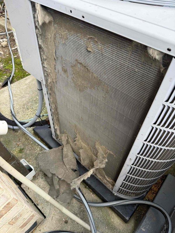 Completed spring cooling tune-up on residential HVAC system with three air conditioning units. Performed comprehensive inspection of indoor air handler and outdoor condensing units. Observed heavily soiled condenser filter with significant dust and debris accumulation restricting airflow, along with deteriorated insulation material at base of unit requiring attention. Documented equipment conditions including mechanical room components and outdoor unit internal components for maintenance records.