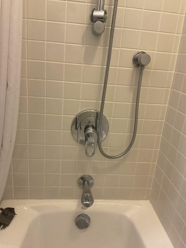 Responded to a leaking tub spout issue in a bathroom with white tile surround and chrome fixtures. Removed the existing stem from the tub spout to obtain proper measurements and specifications for matching replacement parts, which will be picked up and installed to resolve the leak.