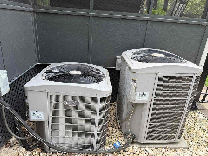 Completed preventive maintenance agreement service on two Carrier condensing units located in exterior residential installation. Performed comprehensive inspection of both systems, verified proper operation of fan motors and compressors, and documented equipment condition through photographic records. Units found operating within normal parameters with adequate clearances and proper gravel pad installation for drainage and equipment support.