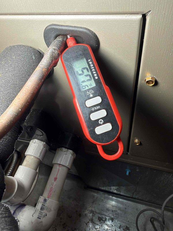 Responded to no cooling call and arrived on site to diagnose air conditioning system that was completely off. Performed system diagnostics using digital measurement tools and inspected refrigerant lines, recording a temperature reading of 57.3 degrees at the copper line. Documented equipment condition with photos showing HVAC unit with diagnostic gauge displaying indicator lights and overall system status for further assessment and repair recommendations.