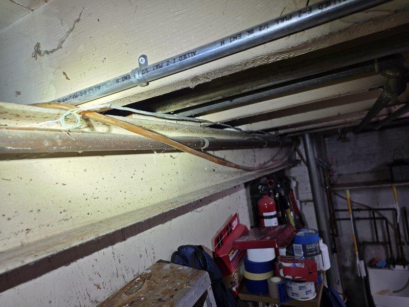 Responded to installation callback regarding condensate pump discharge line. Customer reported that original installation tied into existing water supply line to sink rather than running new dedicated drain line. Documented current installation configuration with photos showing HVAC equipment location and existing plumbing connections in utility area for further evaluation and corrective action planning.