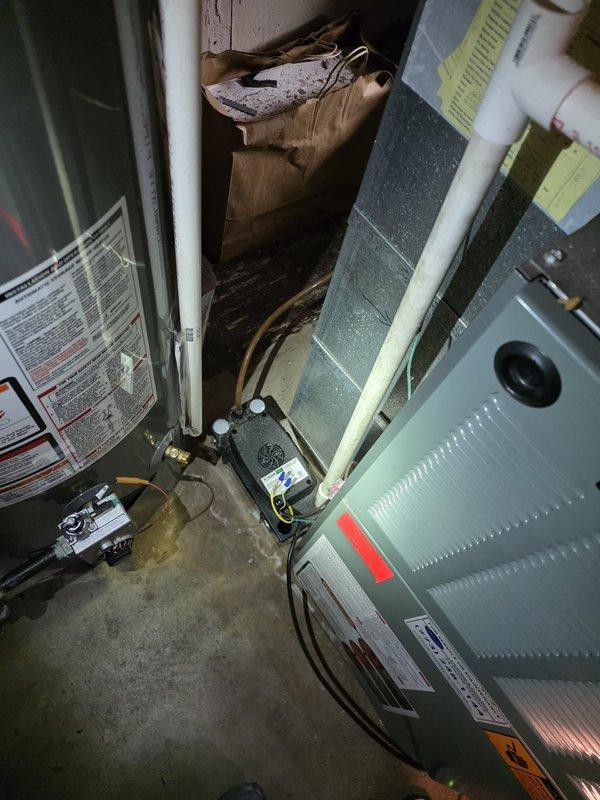 Responded to installation callback regarding condensate pump discharge line. Customer reported that original installation tied into existing water supply line to sink rather than running new dedicated drain line. Documented current installation configuration with photos showing HVAC equipment location and existing plumbing connections in utility area for further evaluation and corrective action planning.