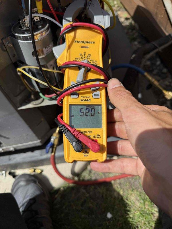 Returned to complete previously sold maintenance work on residential air conditioning system. Performed blower wheel cleaning to improve airflow efficiency. Installed compressor saver hard start capacitor to reduce inrush current and extend compressor lifespan. Applied AC Renew treatment to system. Verified electrical measurements using clamp meter, confirming proper amperage draw of 52.0 amps. Inspected existing dual capacitor and newly installed Pro Tech compressor saver capacitor, ensuring secure mounting and proper wire connections. All components functioning within normal operating parameters upon completion.