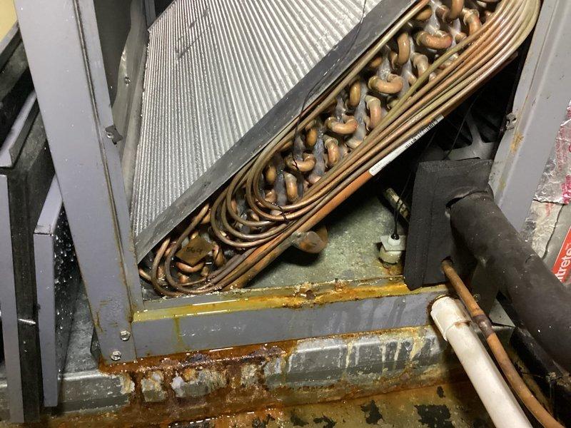 Responded to no cooling call for two Space Pak AC systems. Accessed attic-mounted air handlers via ladder and inspected both units. Found significant corrosion and rust on evaporator coil assemblies, particularly in drain pan areas and lower frame sections. Copper refrigerant tubes showed extensive oxidation and patina buildup. Inspected control boards and electrical panels, verified wiring connections and terminal blocks were secure. Checked LCD display readings on circuit boards. Documented condition of heat exchanger coils showing age-related deterioration with mineral deposits and white residue buildup from condensation. Photographed affected components including finned coil surfaces, U-bend copper tubing, and electrical control systems for service records.