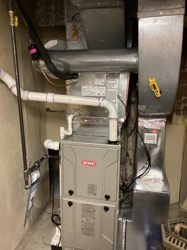 Completed full air conditioning system replacement including outdoor condensing unit and indoor evaporator coil. Installed new Bryant-compatible outdoor A/C unit on existing concrete pad with proper refrigerant line connections and electrical disconnect, ensuring adequate clearance from brick wall and fence. Replaced indoor evaporator coil above existing furnace, integrated new condensate drain lines with PVC piping, and verified all ductwork connections with proper insulation at joints to prevent air leakage and condensation issues.