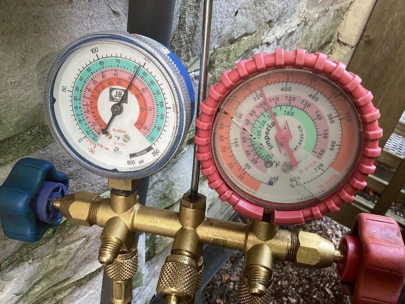 # HVAC Cooling System Repair

Responded to service call for residential HVAC system not cooling properly and blowing warm air. Upon arrival, performed diagnostic evaluation of the cooling system to identify the root cause of the malfunction.

Utilized digital manifold gauge set to measure refrigerant pressures on both high and low side of the system. Connected gauges to service ports and observed pressure readings to assess refrigerant charge levels and system performance. Pressure analysis indicated abnormal readings consistent with refrigerant charge issues.

Employed handheld digital measurement device to verify system parameters and confirm diagnostic findings. Measurements revealed system operating outside of manufacturer specifications, confirming cooling capacity loss.

Based on diagnostic results, identified refrigerant charge deficiency as primary cause of inadequate cooling performance. System pressures and temperature differentials indicated insufficient refrigerant levels p