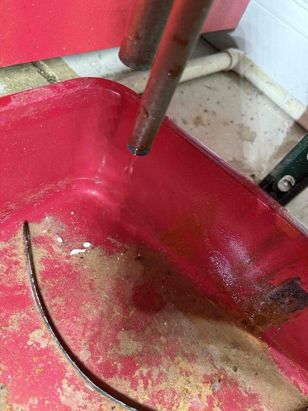 # HVAC Service Call - Overflowing Drain Pan

Responded to service call for overflowing condensate drain pan on air conditioning system. Upon inspection, found significant water accumulation in the primary drain pan with visible rust staining and corrosion on the metal components. The condensate drain line showed signs of blockage, preventing proper drainage from the evaporator coil assembly.

Cleared the clogged condensate drain line to restore proper water flow and drainage. Inspected the drain pan for structural integrity and confirmed it was still serviceable despite surface rust. Verified the condensate pump operation and ensured all drainage pathways were functioning correctly. System tested successfully with proper condensate removal confirmed during operation.