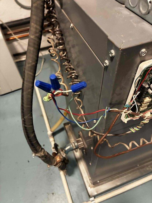 Responded to service call for non-functioning thermostat. Inspected existing Honeywell digital thermostat displaying 73 degrees on wall-mounted beadboard. Accessed HVAC system wiring at equipment location and verified low-voltage control circuit connections including red, white, and blue thermostat wires with proper wire nut terminations. System wiring and connections found secure and operational.