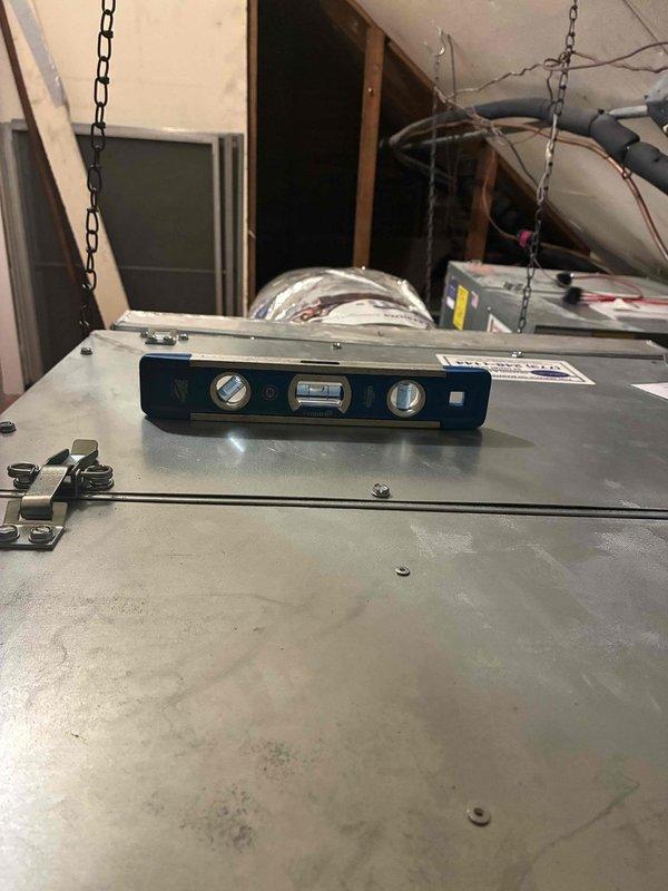Responded to callback for water dripping from Unico system between sections. Inspected installation and verified proper pitch on equipment using digital level to ensure adequate condensate drainage. Documented system positioning and leveling measurements in attic mechanical space to confirm correction of drainage issue.