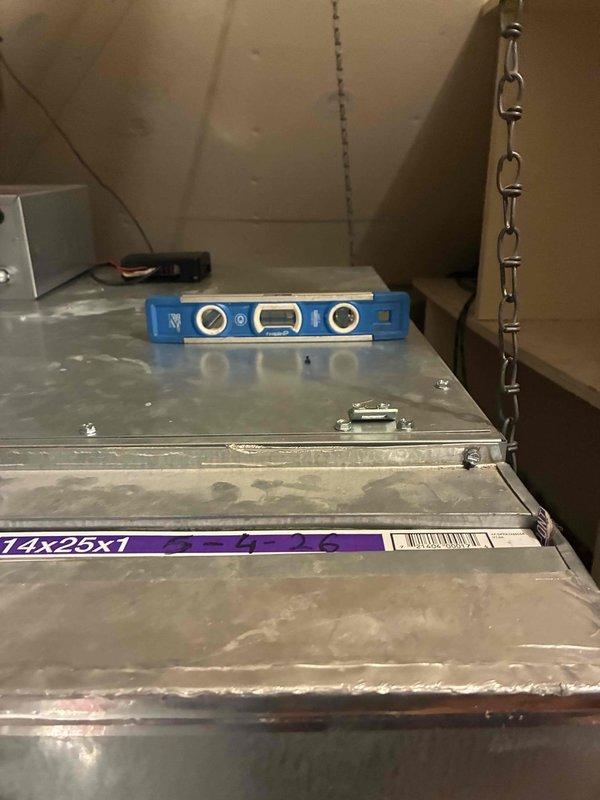 Responded to callback for water dripping from Unico system between sections. Inspected installation and verified proper pitch on equipment using digital level to ensure adequate condensate drainage. Documented system positioning and leveling measurements in attic mechanical space to confirm correction of drainage issue.