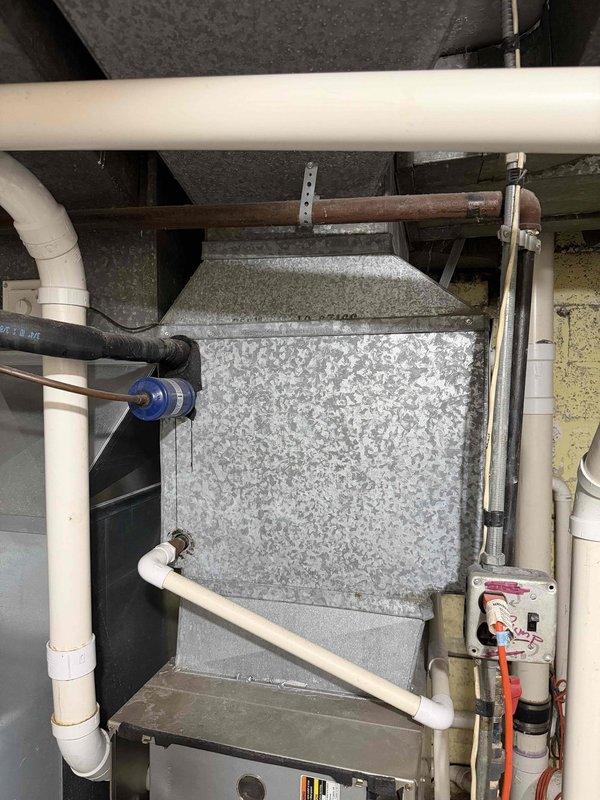 Responded to no-cool complaint on 15-year-old air conditioning system where operation caused electrical buzzing at fuse box, creating potential fire hazard. Upon arrival, performed visual inspection of indoor air handler and outdoor condensing unit. Noted no visible refrigerant leaks, physical damage, or obvious electrical issues at equipment. Connected manifold gauge set to service ports and recorded system pressures. Inspected evaporator coil, condensate drain system with PVC drainage lines, and associated ductwork in attic space. Evaluated electrical connections at air handler control box and wiring integrity. Based on age of equipment and electrical safety concerns at main panel, recommended system replacement due to potential compressor or electrical component failure causing excessive amperage draw. Advised customer to keep system off until repairs completed to prevent fire risk. Documented conditions with photos of air handler installation and pressure readings for records.