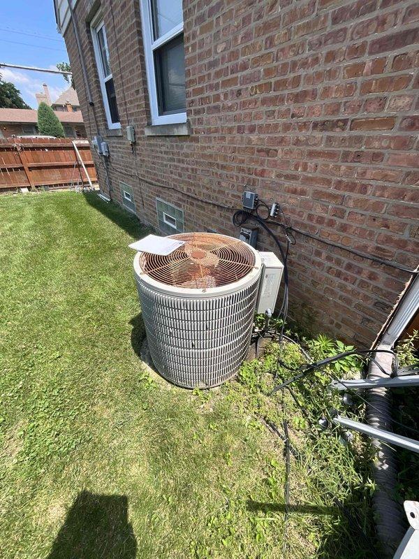 Replaced 20-year-old residential air conditioning system and 18-year-old furnace due to failed evaporator coil and complete refrigerant loss in obsolete R22 system. New HVAC equipment installed in basement mechanical room with updated condensate drainage system and exterior condenser unit positioned against brick exterior wall with proper electrical disconnect and refrigerant line routing.